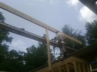 Carpenter setting a ridge beam over a new addition frame — Ice Dam Removal by Roofing Brothers in Accident