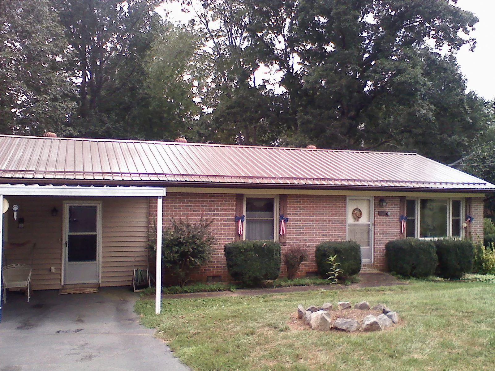 Bronze metal roof and carport on a brick ranch home — Roof Repair work by our crew in Accident